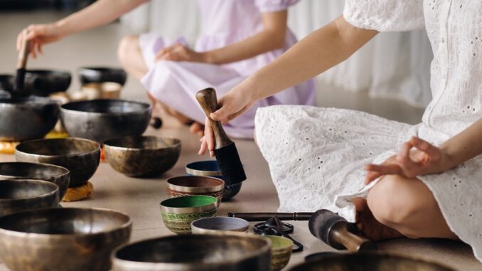 Close-up of a Tibetan singing bowl in your hands - Translation of mantras: transform your impure body, speech and mind into a pure exalted body, speech and mind of a Buddha Take a Sound Bath